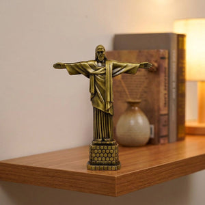 Statue du Christ Rédempteur miniature en métal doré posée sur une étagère