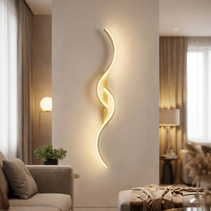 Applique murale LED dorée au design ondulé allumée sur un mur de salon