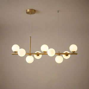 Lustre boule de verre finition dorée allumé sur fond neutre chaleureux