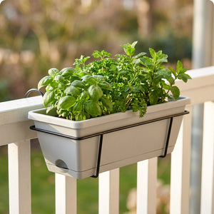 Jardinière de balcon suspendue coloris gris avec herbes sur rampe