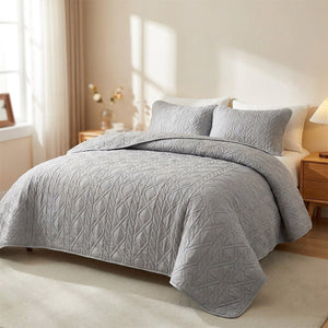 Couvre-lit matelassé gris avec taies d'oreiller sur un lit