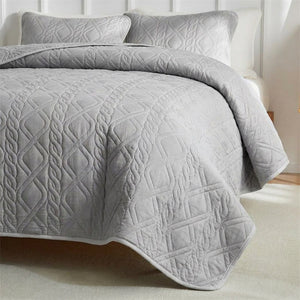 Couvre-lit matelassé gris gros plan sur le motif losange