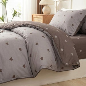 Housse de couette taupe à petits cœurs marron avec taies assorties sur un lit