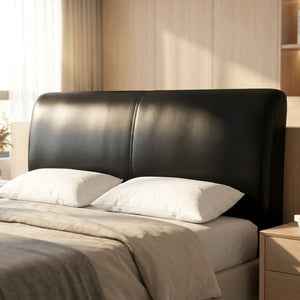 Housse de tête de lit noire effet cuir installée sur un lit dans une chambre chaleureuse