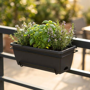 Jardinière de balcon suspendue coloris noir avec herbes sur rambarde
