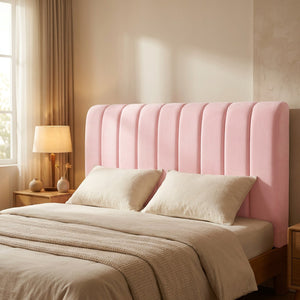 Housse de tête de lit rose capitonnée installée sur un lit