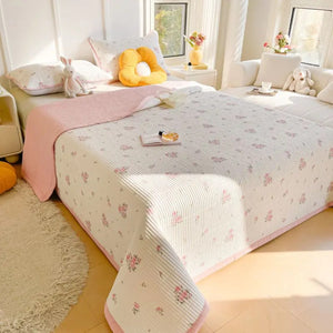 Couvre-lit matelassé coloris rose motifs floraux sur un lit