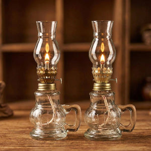 Deux lampes à pétrole en verre transparent allumées côte à côte