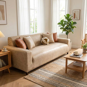 Salon lumineux avec canapé recouvert d'une housse beige et coussins en velours