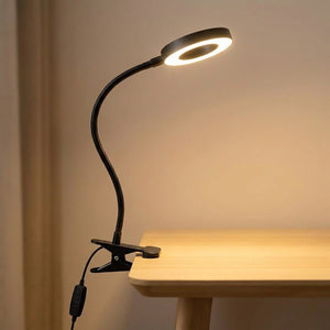Lampe de bureau à pince noire avec bras flexible col de cygne allumée
