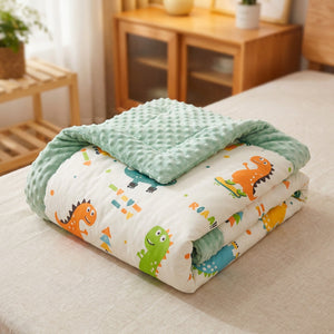 Couette bébé motif dinosaures repliée montrant le tissu doux
