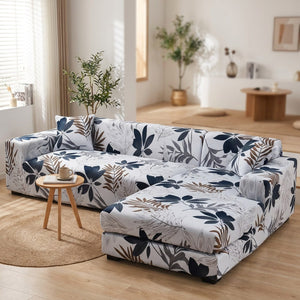 Housse de canapé d'angle motif feuillage blanc et bleu marine dans un salon lumineux