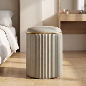 Tabouret de rangement rond gris à l'assise rembourrée et liseré doré