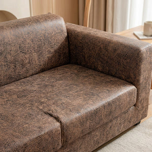 Housse de canapé marron effet cuir vieilli, gros plan sur l'assise et l'accoudoir