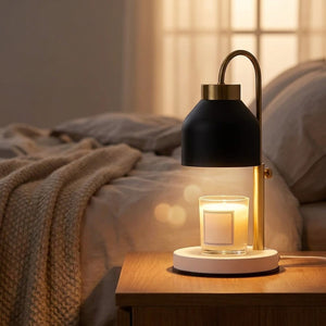 Lampe chauffe-bougie noire sur table de nuit avec bougie allumée