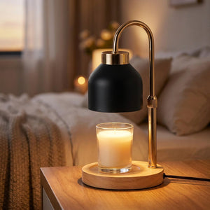 Lampe chauffe-bougie noire sur table de nuit avec bougie allumée