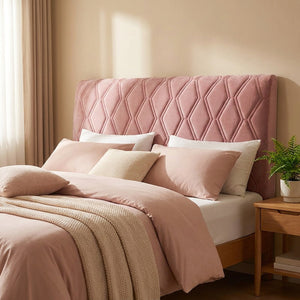 Housse de tête de lit en velours matelassé rose sur un lit