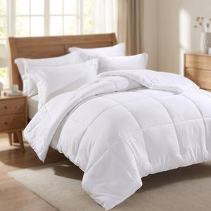 Couette blanche moelleuse posée sur un lit avec tête de lit en bois