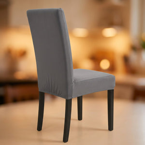 Housse de chaise grise extensible et imperméable sur une chaise de salle à manger