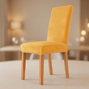 Housse de chaise jaune en velours moelleux sur une chaise de salle à manger
