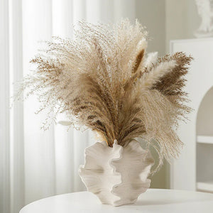 Vase céramique beige avec herbe de pampa dans un intérieur nordique