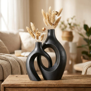 Duo de vases en céramique noire enlacés garnis de pampas dans un salon chaleureux