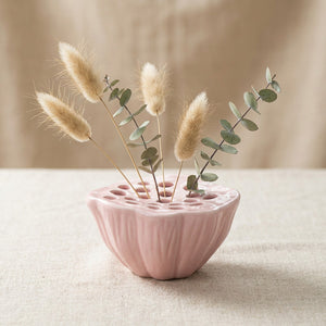 Vase Ikebana en céramique rose en forme de graine de lotus avec pampas sur surface en lin