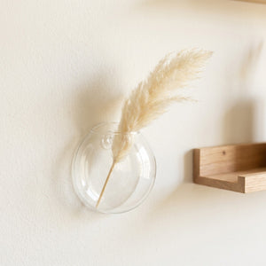 Vase mural en verre avec herbe de pampa dans intérieur nordique