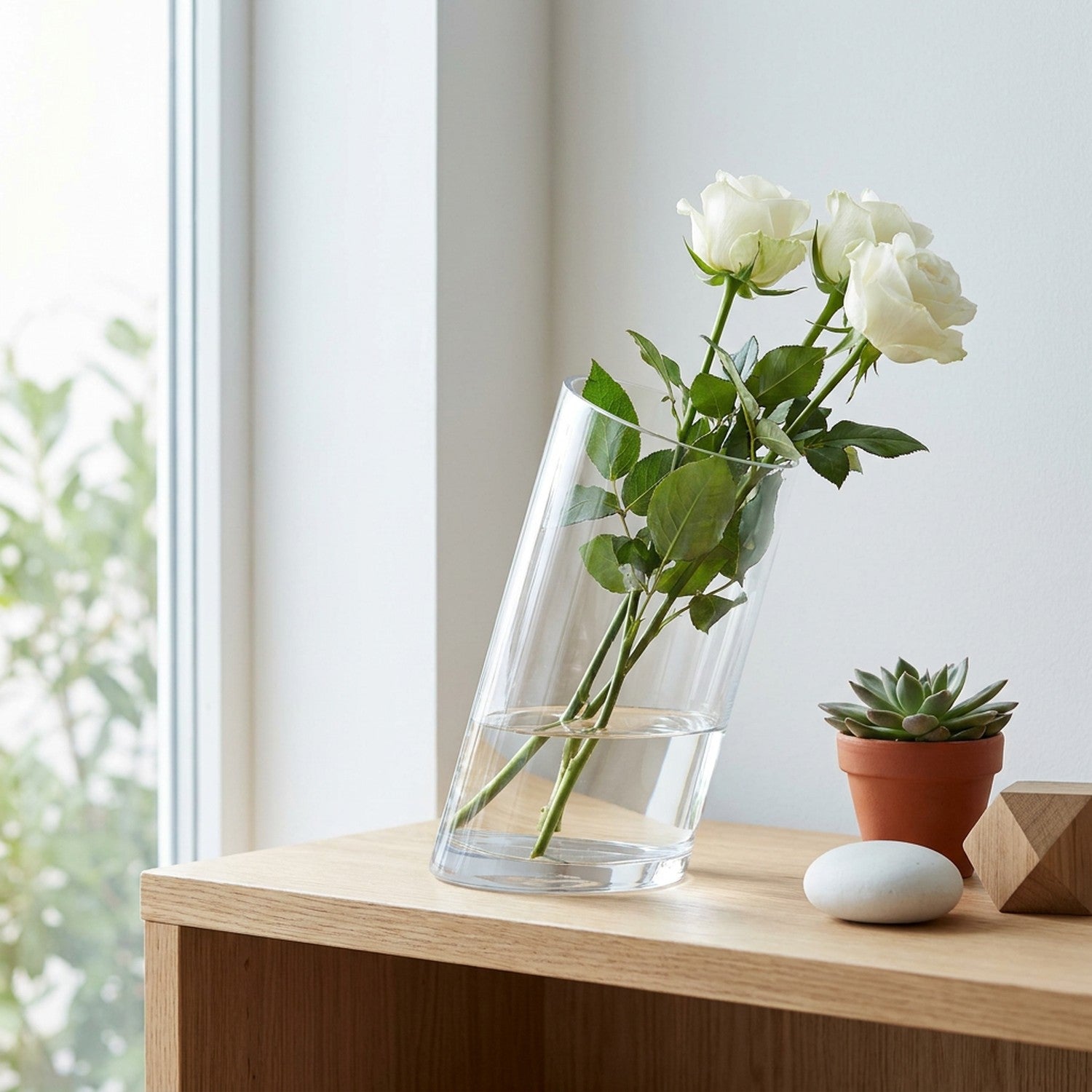 Vase verre transparent bouche inclinée sur étagère bois avec fleurs