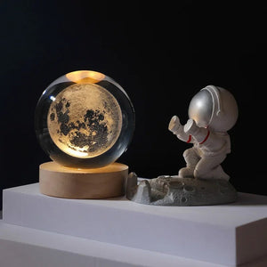 Boule de cristal gravée de la lune allumée sur socle en bois