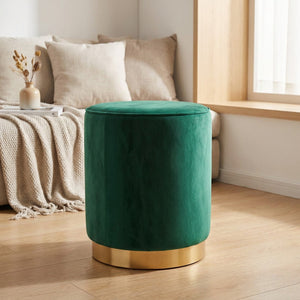 Tabouret rond en velours vert émeraude avec socle doré posé dans une chambre chaleureuse