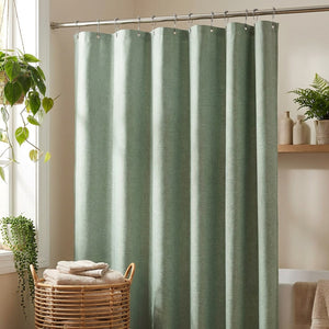Rideau de douche aspect lin vert sauge dans une salle de bain botanique