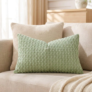 housse de coussin rectangulaire en maille texturée vert sauge sur un canapé en lin