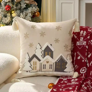 Housse de coussin brodée d'un village enneigé sur canapé décoré de Noël