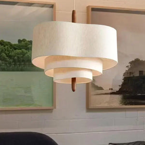 Suspension wabi sabi en lin écru vue de face devant des cadres décoratifs