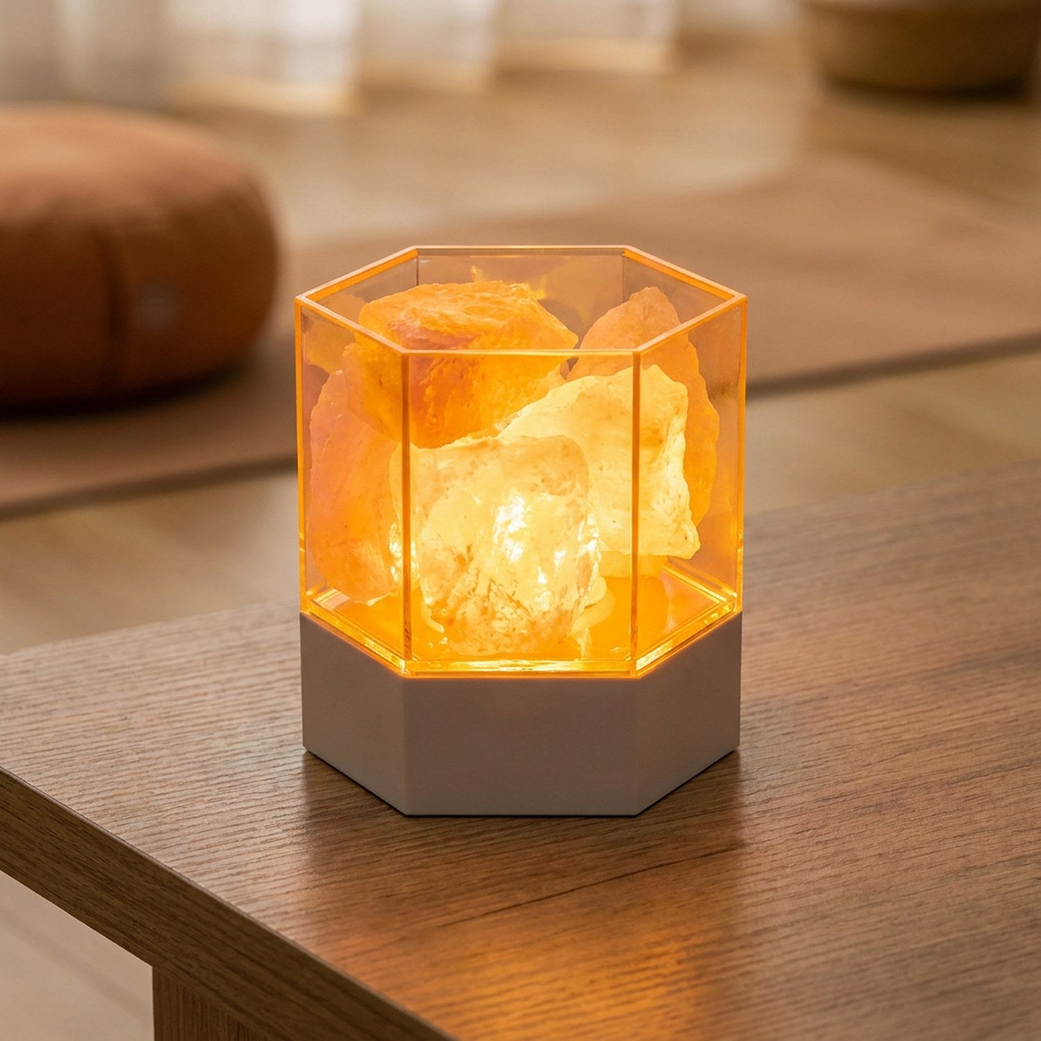 Lampe de sel hexagonale en cristal allumée sur une table basse en bois