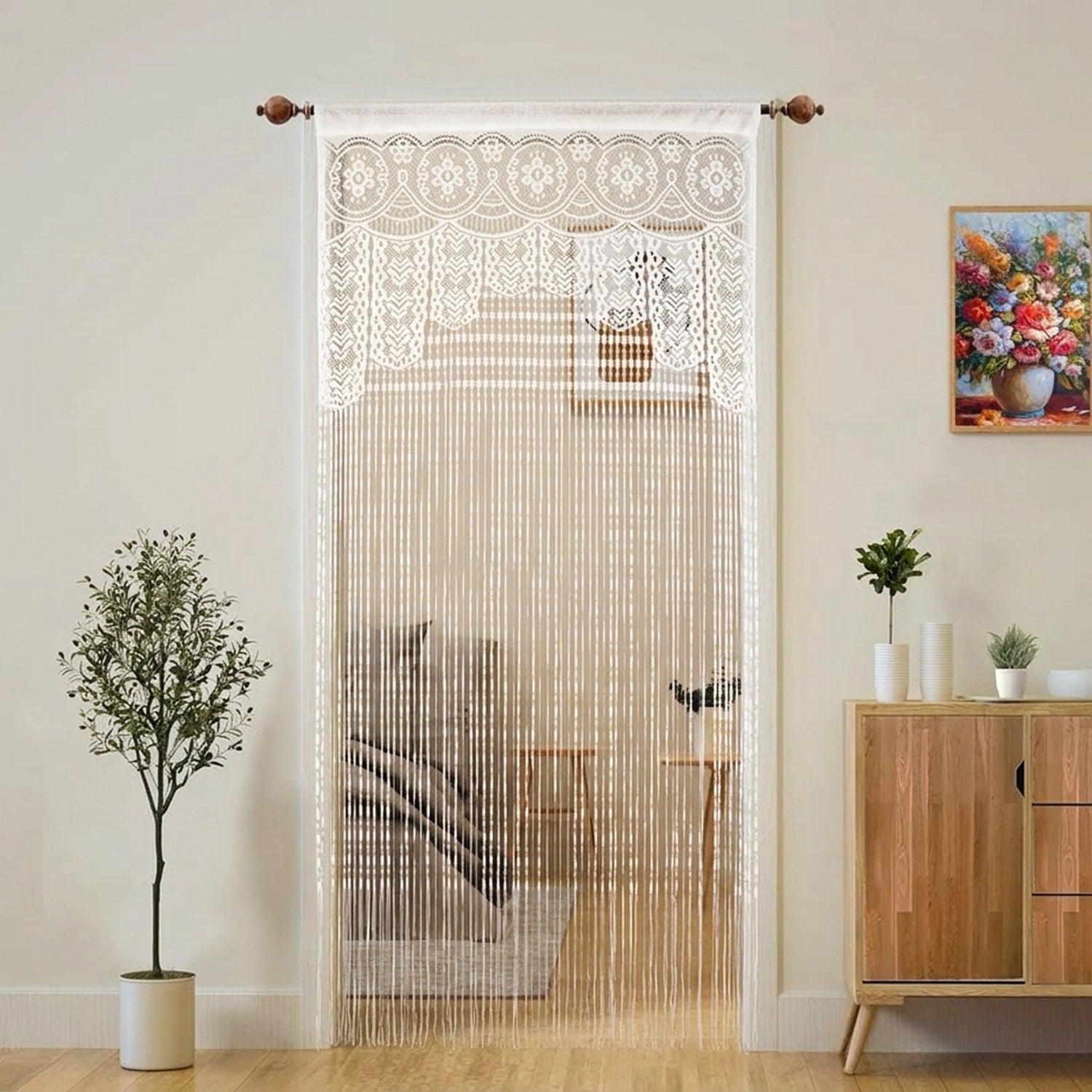Rideau de porte en macramé blanc à franges suspendu à une tringle dans un intérieur lumineux