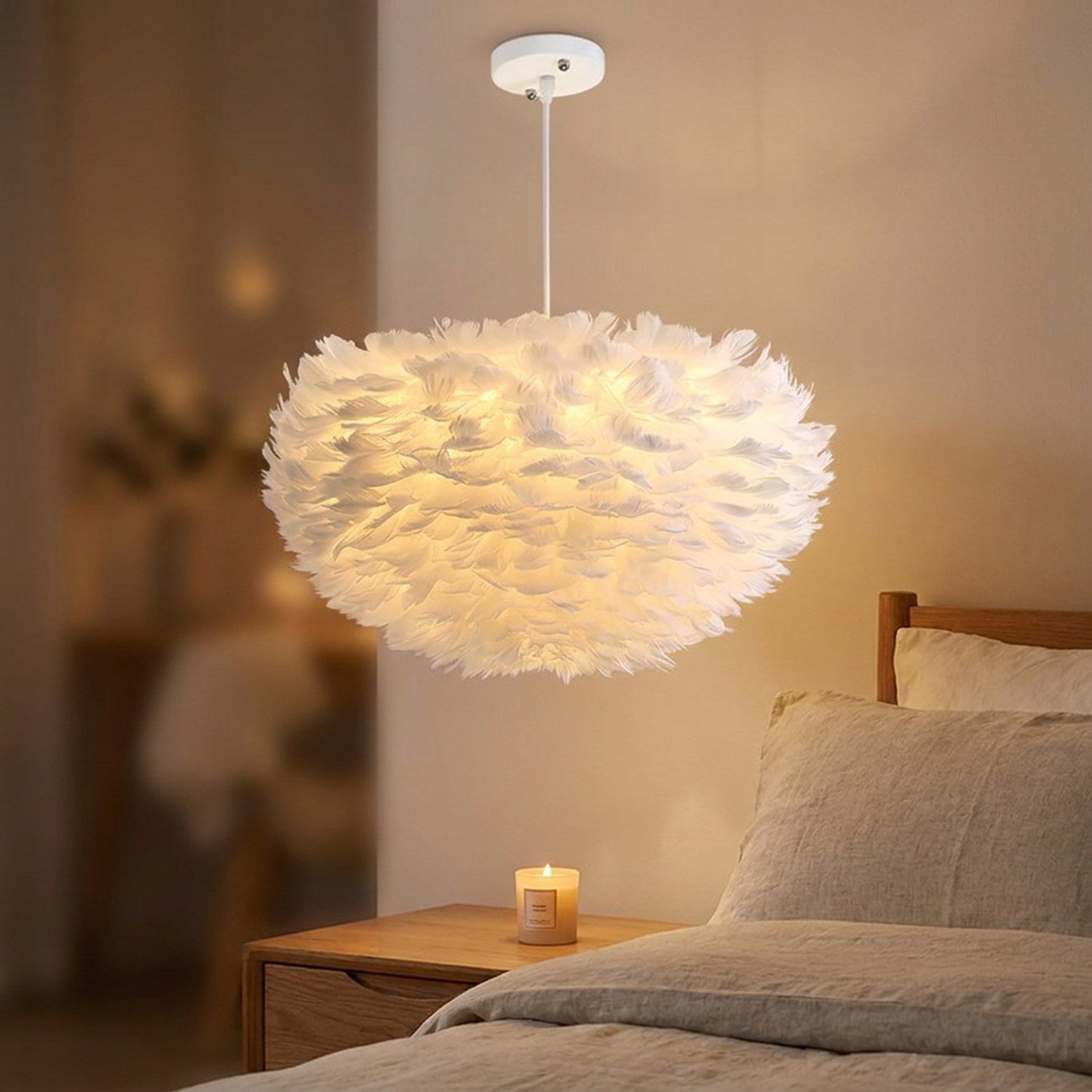 Suspension boule en fausses plumes blanches allumée au-dessus d'un lit dans une chambre cocooning