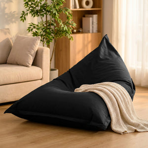 Housse de pouf géant noire en toile imperméable posée dans un salon cosy et lumineux