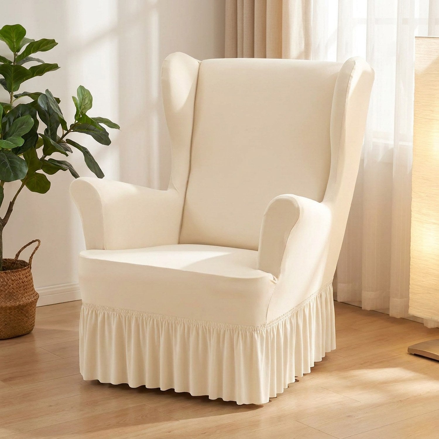 Housse de fauteuil à oreilles écrue avec jupe à volants installée dans un salon lumineux