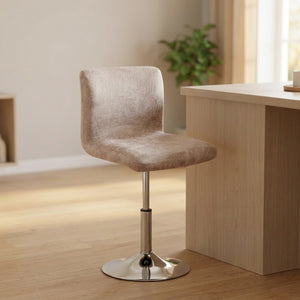 Housse de chaise de bar en aspect daim beige posée sur un tabouret à dossier bas