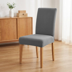Housse de chaise grise extensible sur une chaise de salle à manger