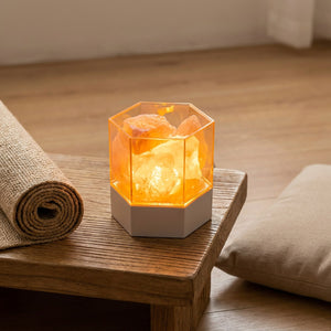 Lampe de sel hexagonale posée près d'un tapis de yoga roulé