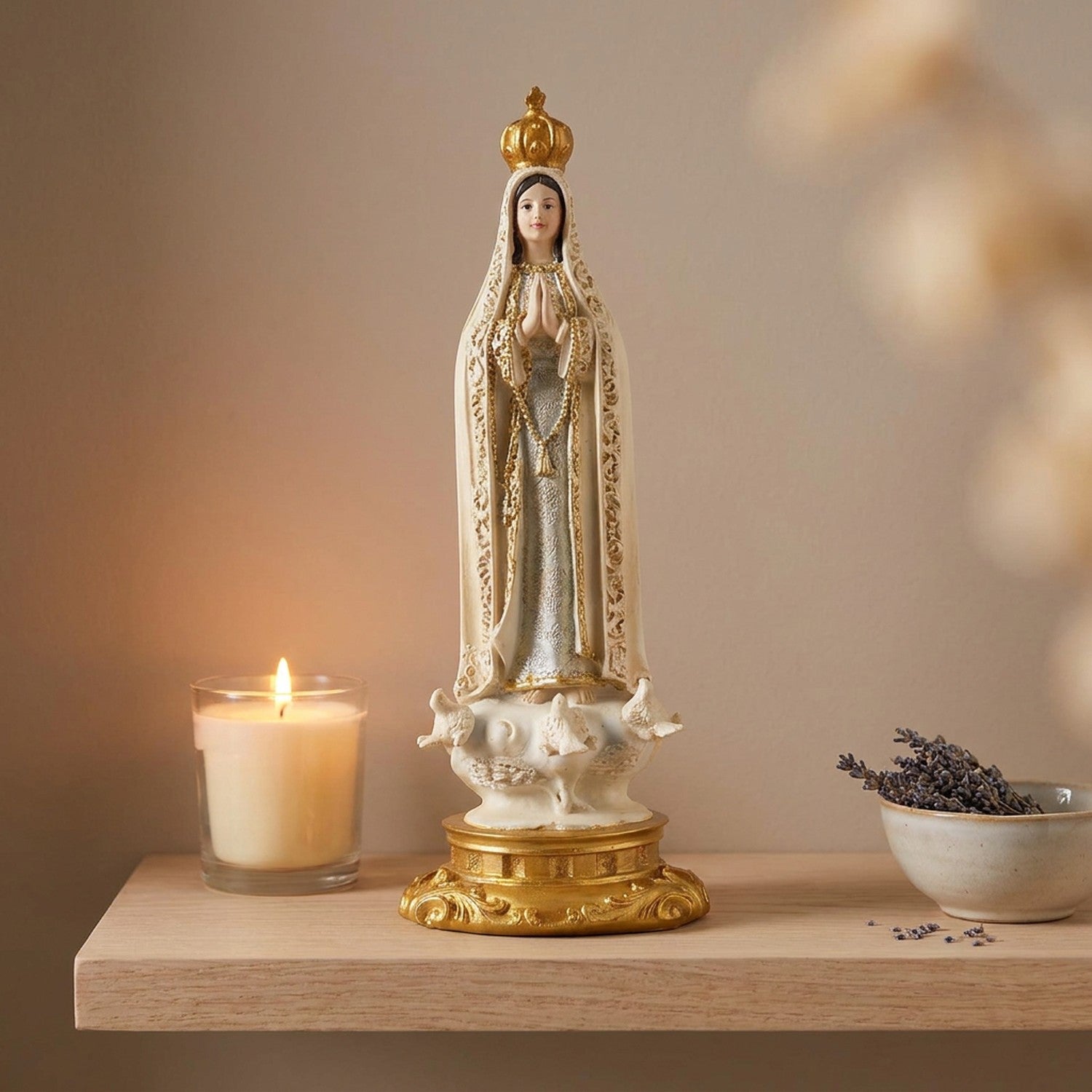 Statue de la vierge Marie de Fatima sur une étagère claire près d une bougie allumée