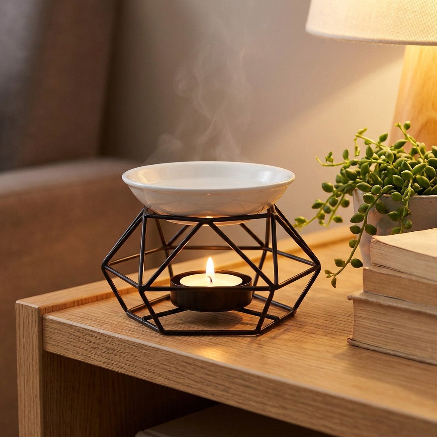 Brûle-parfum géométrique noir allumé sur une étagère en bois près d'une plante verte