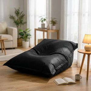 Housse de pouf géant noire installée en coin lecture près d'une fenêtre lumineuse
