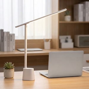 Lampe de bureau blanche posée sur un bureau de télétravail à côté d un ordinateur