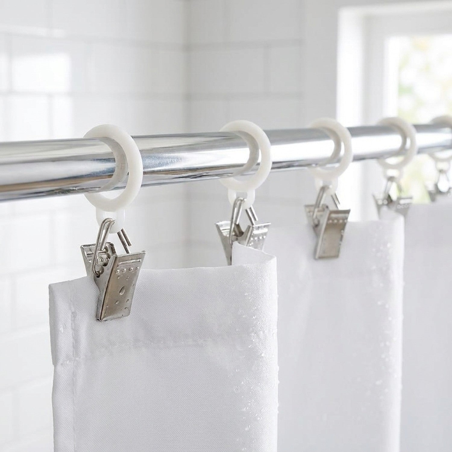 Rideau de douche blanc fixé à une tringle chromée grâce à des pinces à roulettes