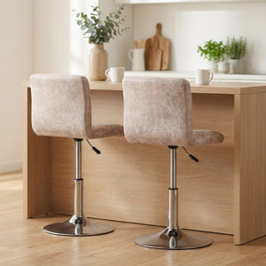 Deux housses de chaise de bar beige assorties sous un îlot de cuisine en bois clair