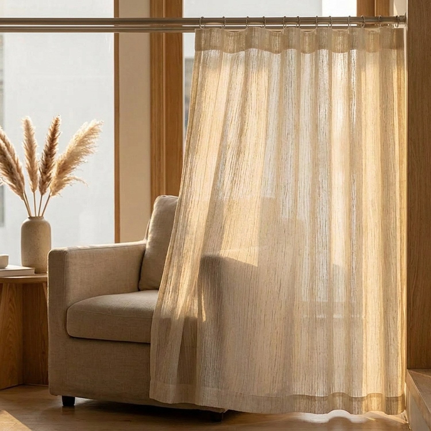 Voilage texturé beige dans un salon avec un fauteuil et des herbes de pampa